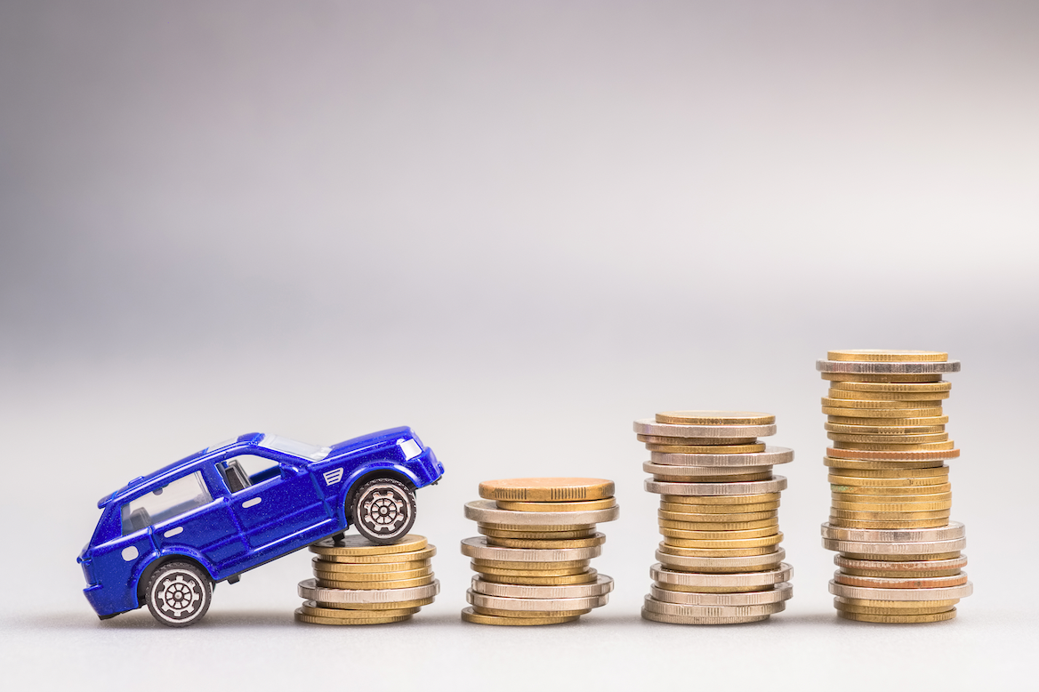 Toy car driving up stacks of coins