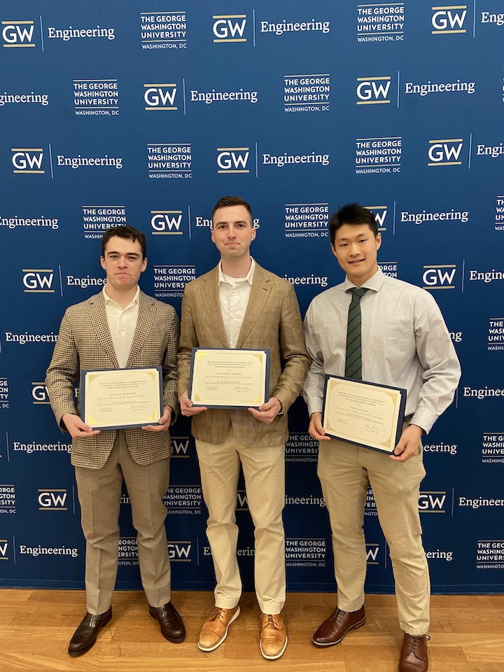 Three students holding certificates