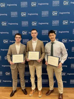 Three students holding certificates