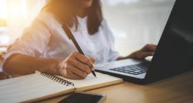 Women writing and working on laptop
