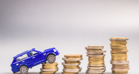 Toy car driving up stacks of coins